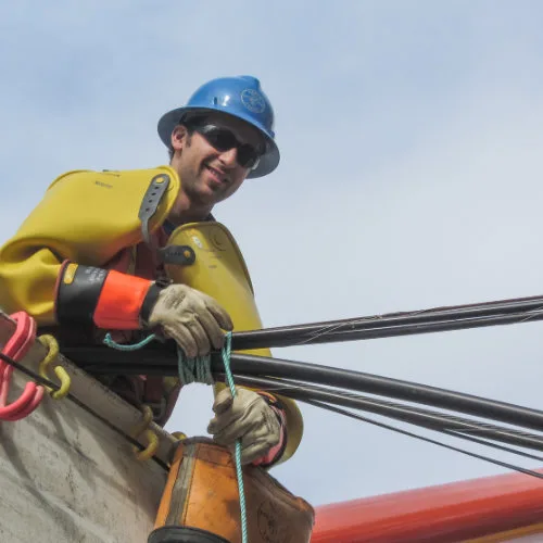 Smiling Metro Power worker in a bucket truck installing power lines